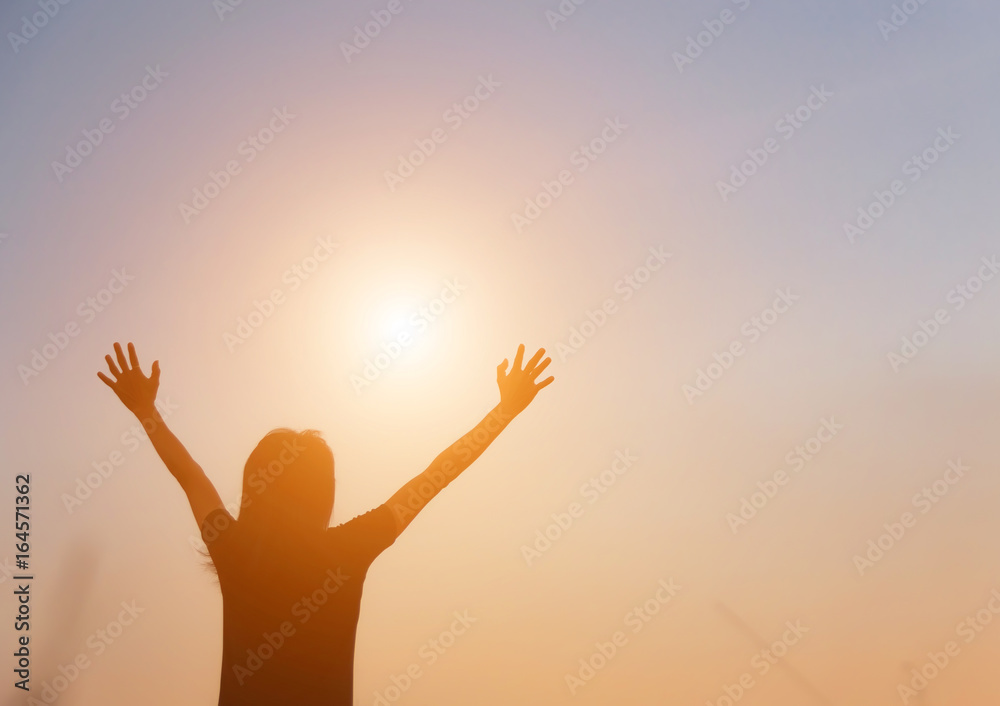 Silhouette of woman praying over beautiful sky background Silhouette of woman praying over beautiful sky background