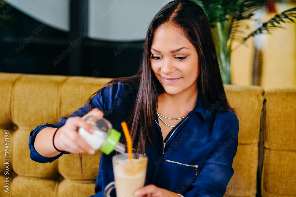 Beautiful girl drinking ice mocha shake in a cafe Beautiful girl drinking ice mocha shake in a cafe