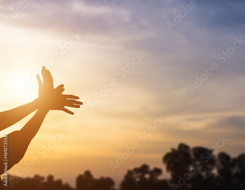 hands forming a shape with sunset silhouette