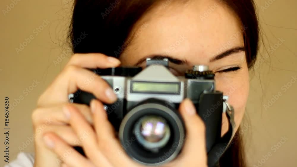 Girl makes a photo on the old camera. Photoshoot. Retro. Close-up Girl makes a photo on the old camera. Photoshoot. Retro. Close-up