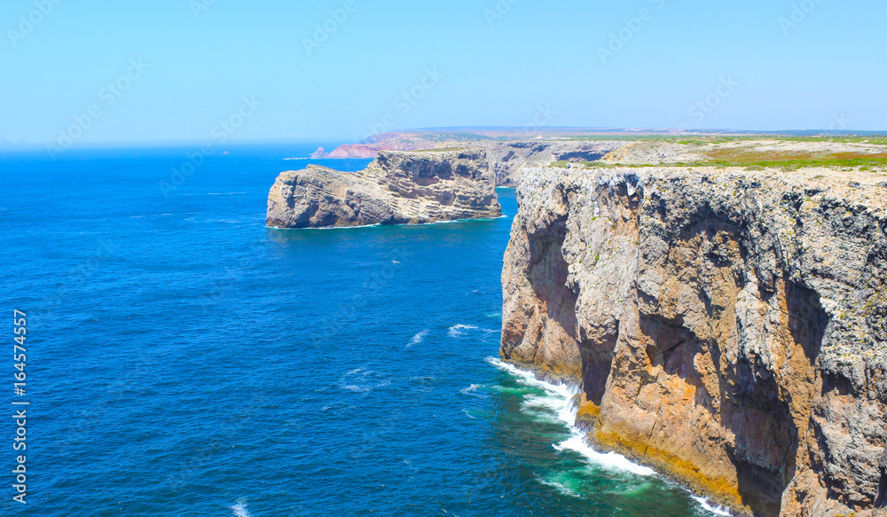View of famous Cliffs of Moher and wild Atlantic Ocean, Portuguese coastline close to Cape St. Vincent in Portugal on a sunny and clear day with the beautiful blue Atlantic in the background.
