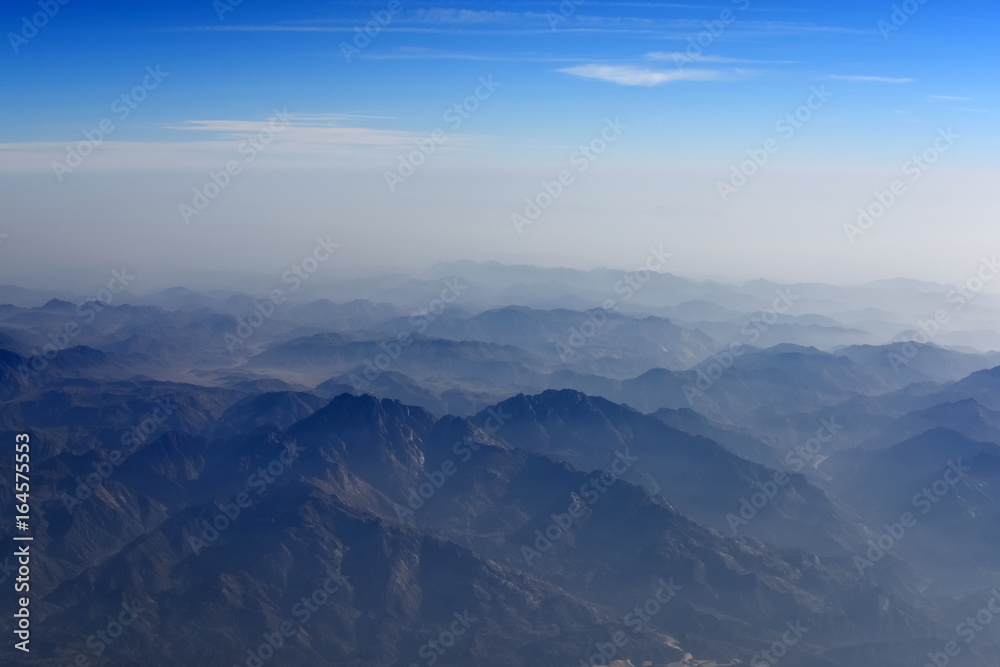 Aerial view of mountain and blue sky from airplane window