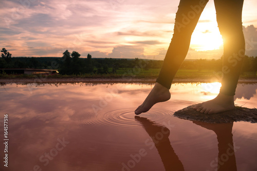 Women's feet on the rocks in the water in the natural beauty.