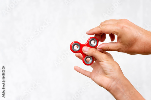 Fidget spinner. Red hand spinner, boys playing with fidgeting hand toy. Stress relief. Anti stress and relaxation adhd attention fad boy concept. Free space for text. photo