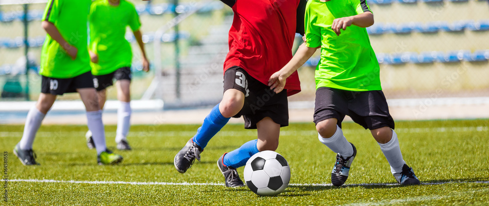 Fototapeta premium Training and football match between youth teams. Young boys playing soccer. Football match for children. Training and football soccer tournament