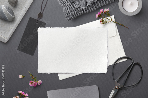 elegant feminine stationery mockup with hand made paper greeting card, pink flowers and lifestyle objects on a grey paper background, flat lay / top view styled photography photo