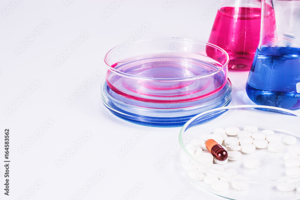 pills analyzing. pills and color liquid in petri dishes. laboratory, science and clinic background. pills analyzing. pills and color liquid in petri dishes. laboratory, science and clinic background.