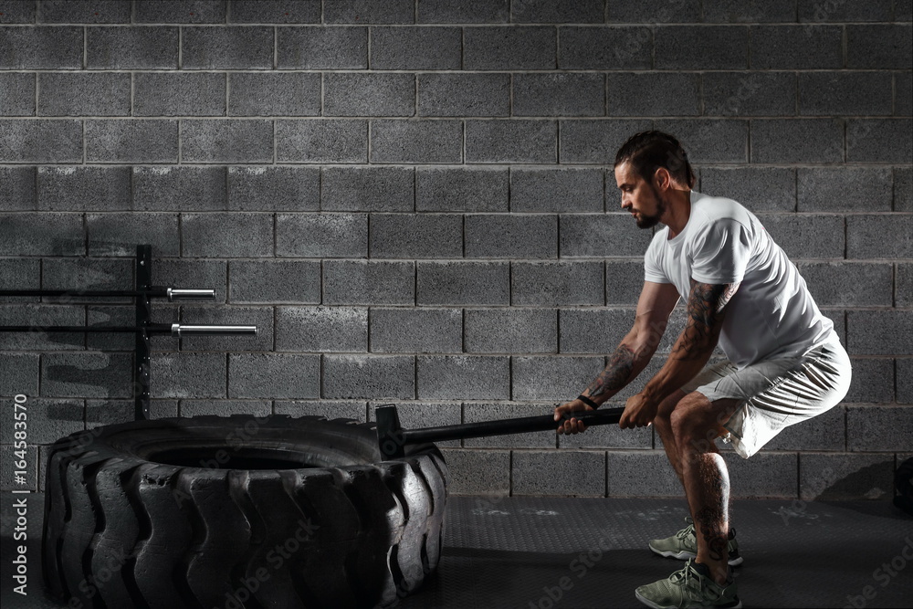 Sport Fitness Man Hitting Wheel Tire With Hammer Sledge Crossfit Training,  Young Healthy Guy Gym Interior Stock Photo | Adobe Stock