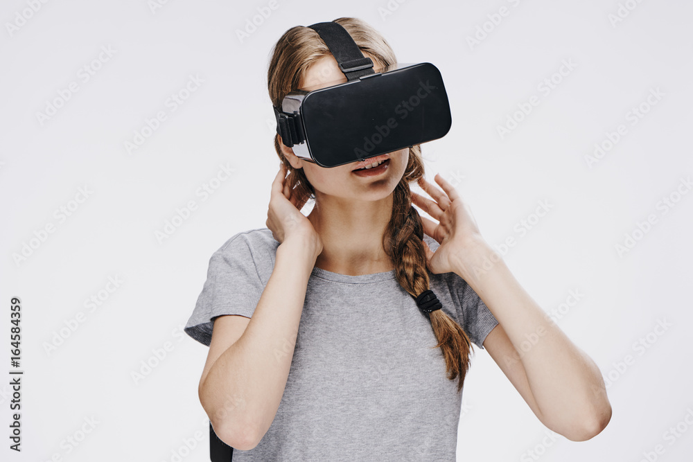 Young beautiful woman on white isolated background in virtual reality glasses Young beautiful woman on white isolated background in virtual reality glasses
