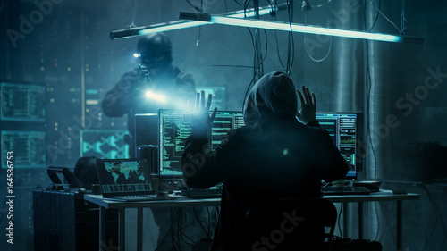 Fully Armed Special Cybersecurity Forces Soldier Arrests Highly Dangerous Hooded Hacker. Hideout is Dark and Full of Computer Equipment.