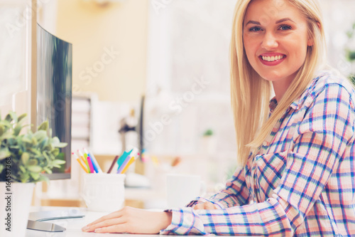 Young woman sitting at her desk in an office