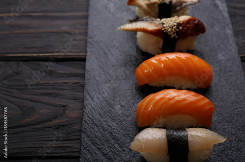 Set of sushi on black wood background, pov