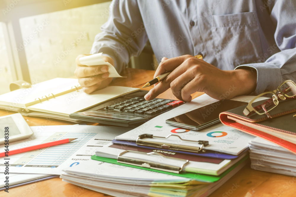business executives working on calculator with data document at the office