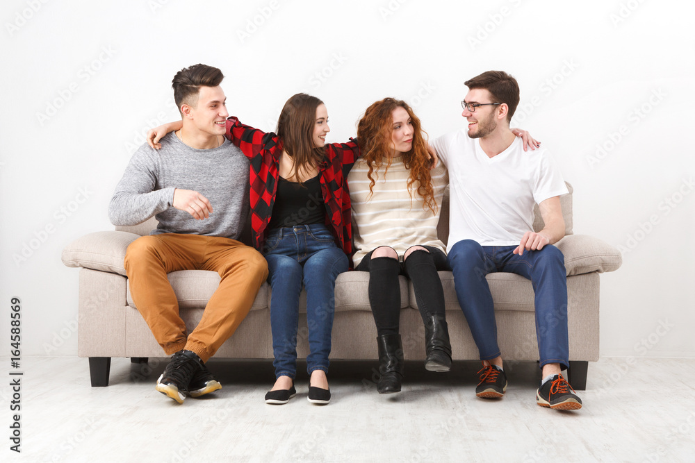 Happy young friends, casual people sitting on couch Happy young friends, casual people sitting on couch