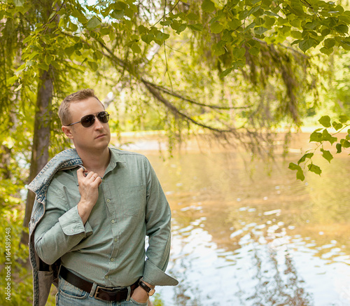 man in a denim suit on the background of the river