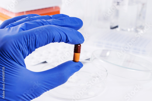 Scientist analyzing pills in medical laboratory photo