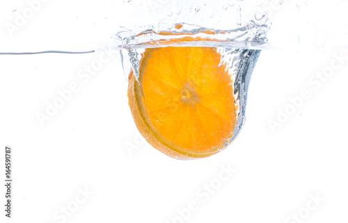 orange slice in water splash. white background