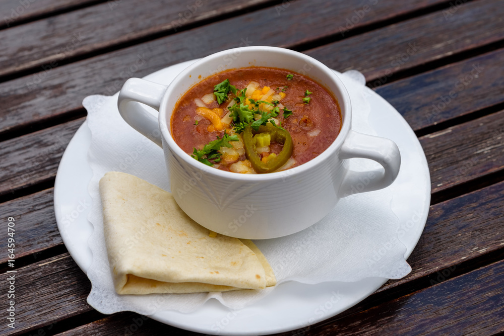 Chili con carne soup in white cup with tortillas. Authentic mexican food. Top view Chili con carne soup in white cup with tortillas. Authentic mexican food. Top view