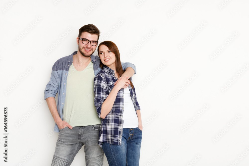 Smiling couple in casual embracing at white studio background, isolated Smiling couple in casual embracing at white studio background, isolated