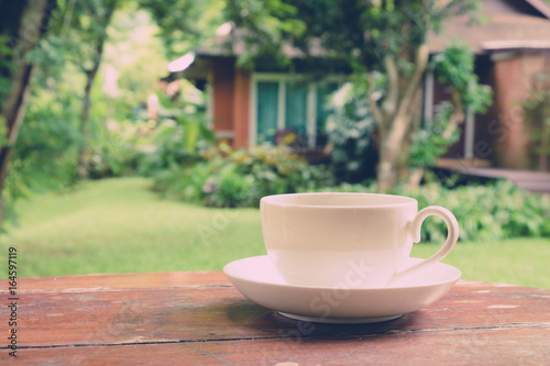 White coffee cup in the garden. (vintage tone)