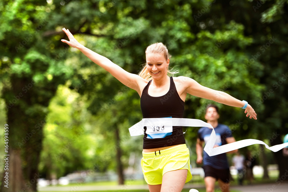 Young woman running in the crowd crossing the finish line. Young woman running in the crowd crossing the finish line.