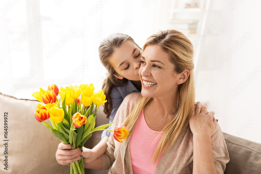 happy girl giving flowers to mother at home happy girl giving flowers to mother at home
