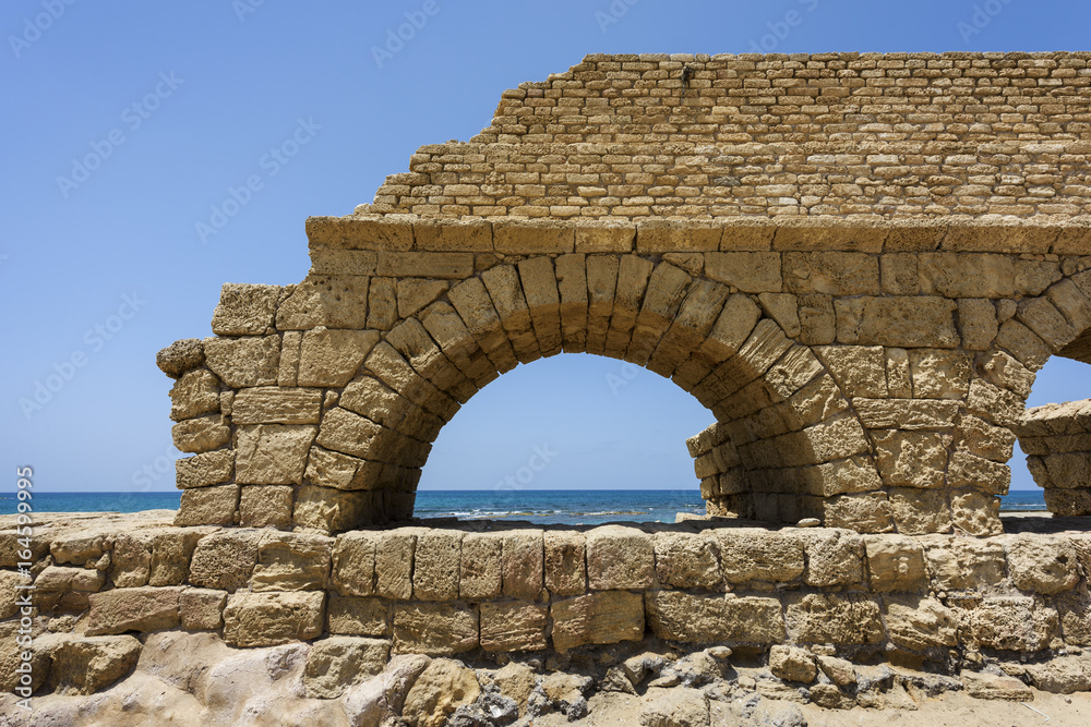 Ancient Roman aqueduct in Ceasarea at the coast of the Mediterranean Sea, Israel