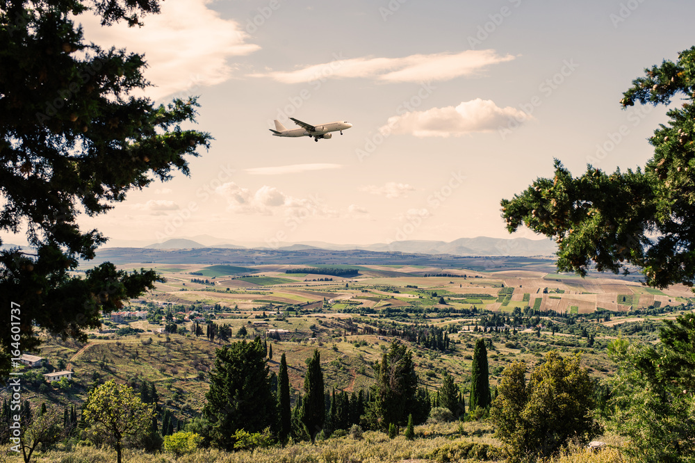 Panorama of the suburbs of the Greek city of Athens with landing plane at sunset Panorama of the suburbs of the Greek city of Athens with landing plane at sunset