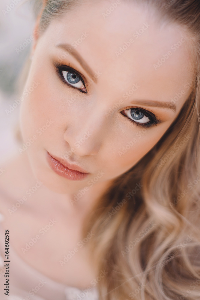 Studio Portrait of Beautiful Model with Volume Shiny Wavy Blond Hair. Fashion Make Up and Curly Ombre Hair. Close up