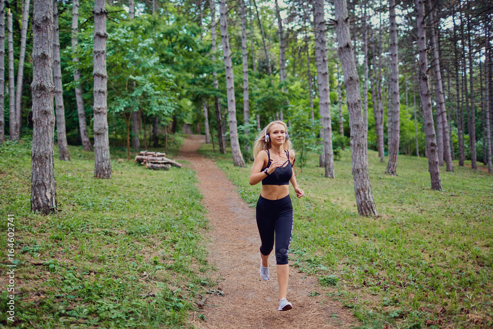 A woman runs jogging through the forest. A woman runs jogging through the forest.