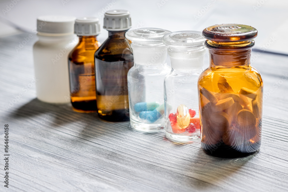 Vitamins and supplements. Pills and pill bottle on grey wooden table background Vitamins and supplements. Pills and pill bottle on grey wooden table background