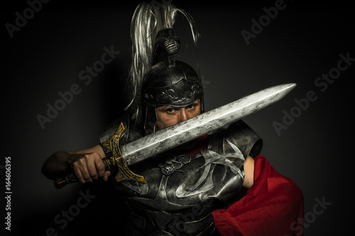Slika na platnu Glory, Roman centurion with armor and helmet with white chalk, steel sword and l