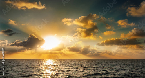 Sunset in the Maldives. Beautiful colorful sunset over the ocean in the Maldives seen from the beach.Amazing sunset and beach in Maldives. Calm water and soft waves. Beautiful maldivian sunbeam.