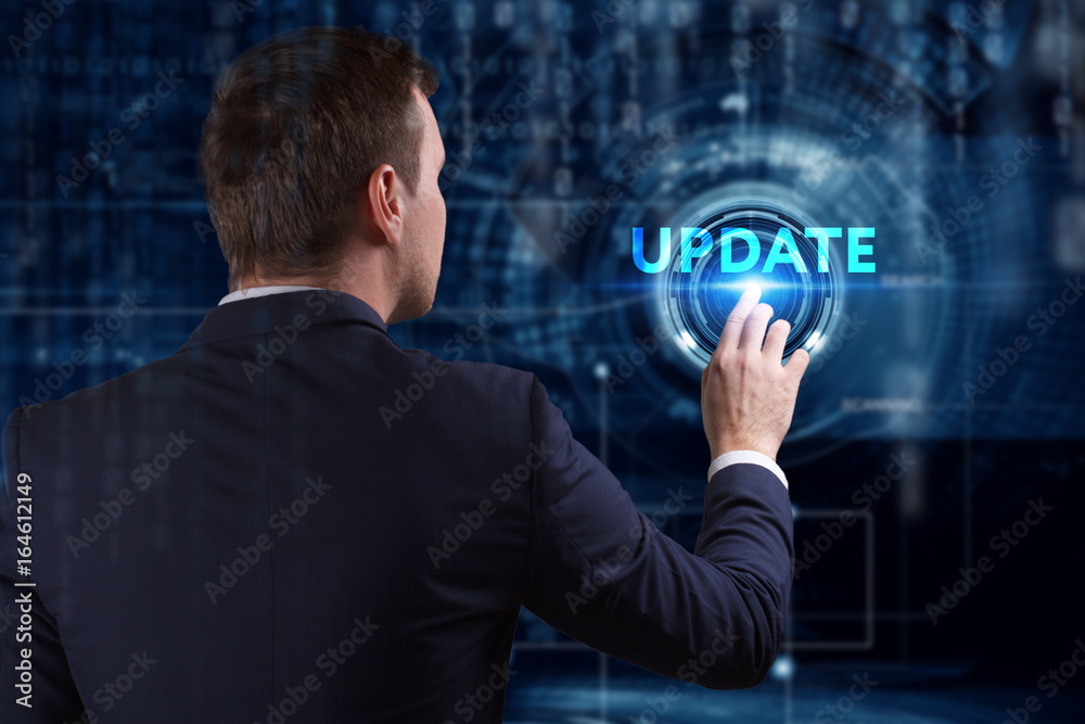 Business, Technology, Internet and network concept. Young businessman working on a virtual screen of the future and sees the inscription: Update Business, Technology, Internet and network concept. Young businessman working on a virtual screen of the future and sees the inscription: Update