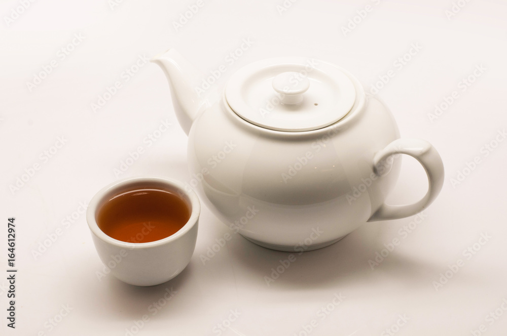 Hot tea in white teacup and white hot pot on white background