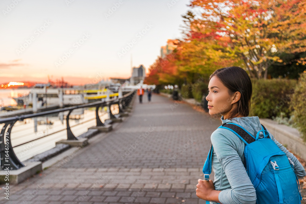 Naklejka premium Ludzie miejskiego stylu życia w mieście Vancouver w Harbour, Kolumbia Brytyjska. Kobieta turysta z plecakiem studenckim w mieście na zewnątrz, ciesząc się jesienią.