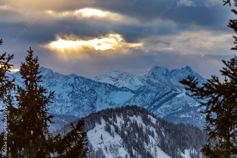 Grühende Wolken über schneeweißen Bergen