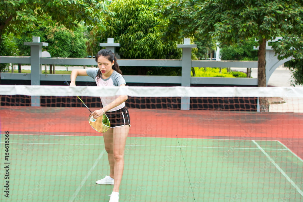 Girl serving on a badminton match outdoors