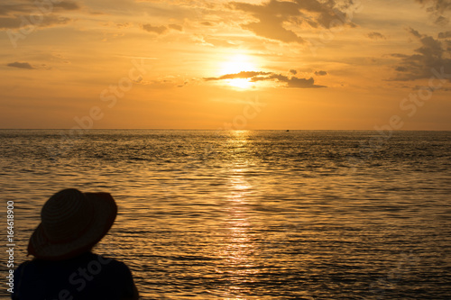 Woman on beach against golden sunset
