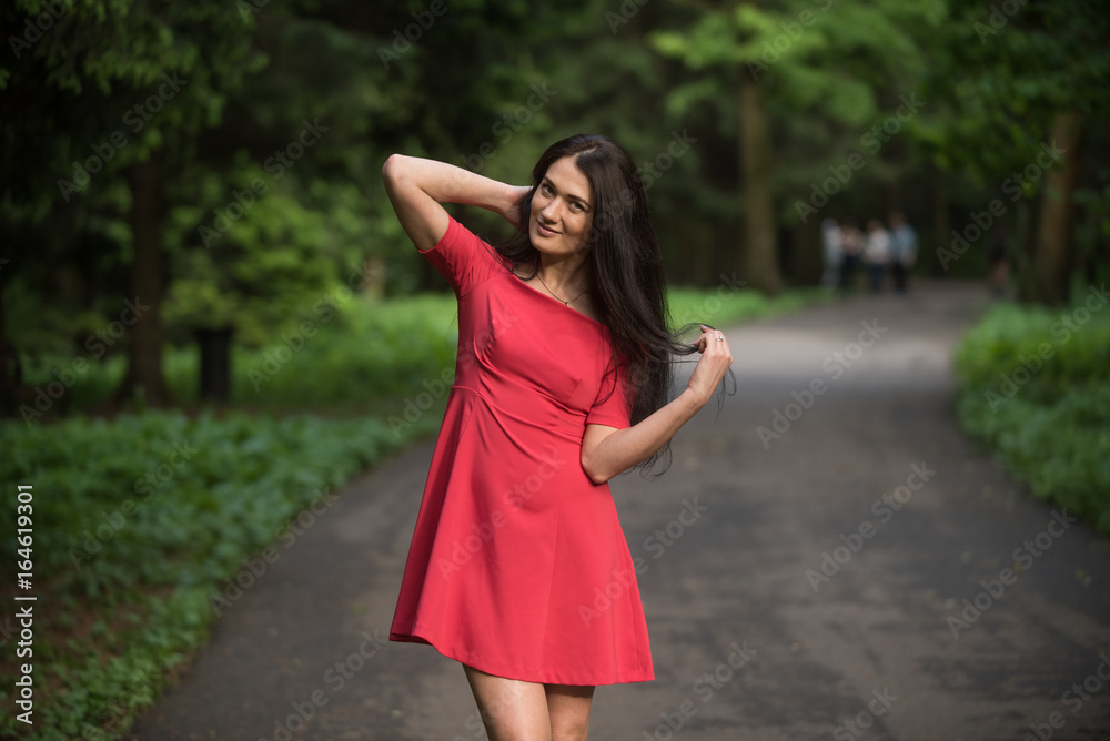 Attractive brunette woman wearing red short dress Attractive brunette woman wearing red short dress