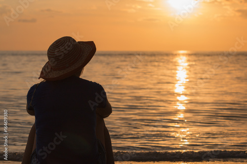 Woman on beach against golden sunset