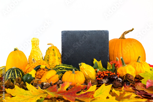 herbstliches Laub, eine Tafel und verschiedene Kürbisse