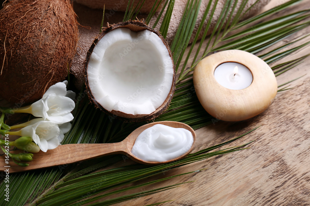 Composition with coconut cream in spoon for spa treatment on wooden background