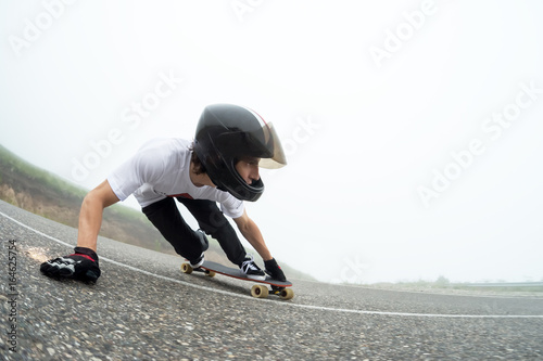 A young guy in a full face helmet in a slide passes a turn