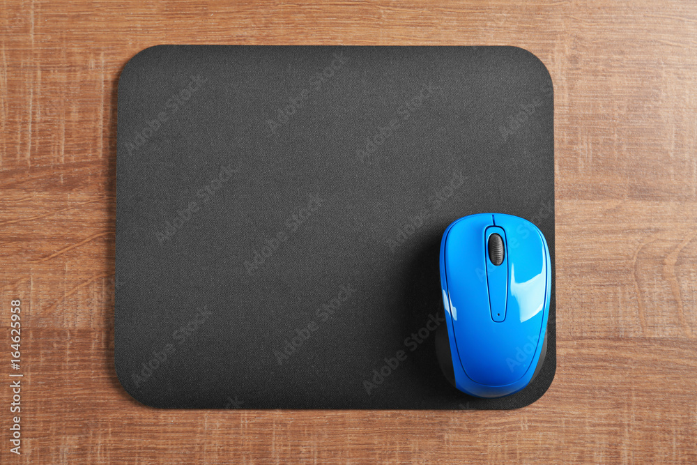 Blank mat and wireless mouse on wooden background Blank mat and wireless mouse on wooden background
