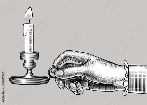 Woman's hand holding a candlestick with burning candle