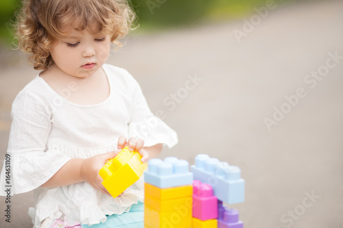 Cute toddler girl playing with constructor blocks