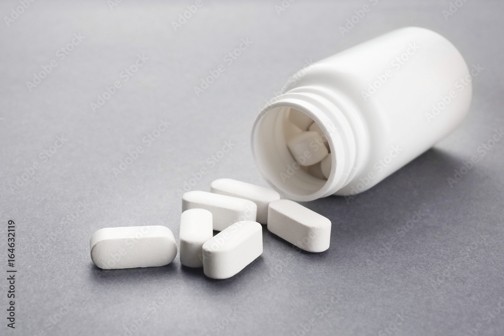 Health care concept. Pills and jar on grey background Health care concept. Pills and jar on grey background