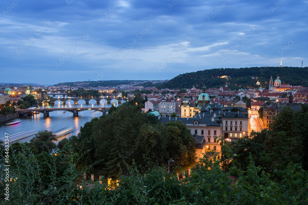 Bridges over Vltava River and buildings at the Mala Strana District (Lesser Town) in Prague, Czech Republic, viewed slightly from above in the evening.