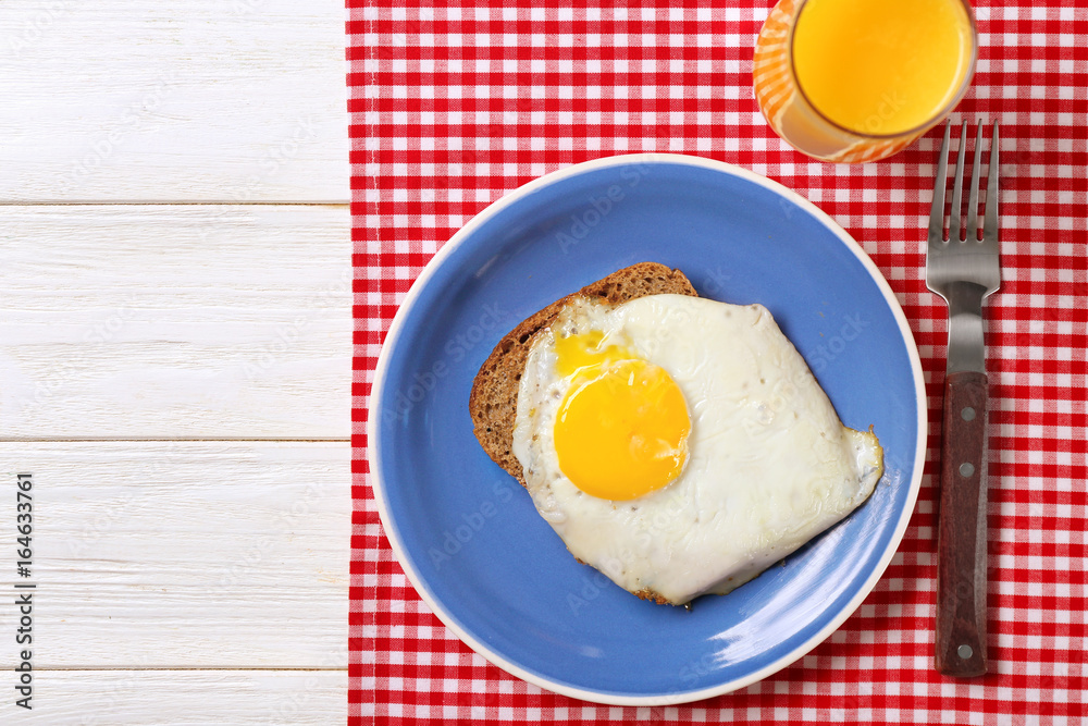 Delicious over easy egg with bread and orange juice on kitchen table Delicious over easy egg with bread and orange juice on kitchen table